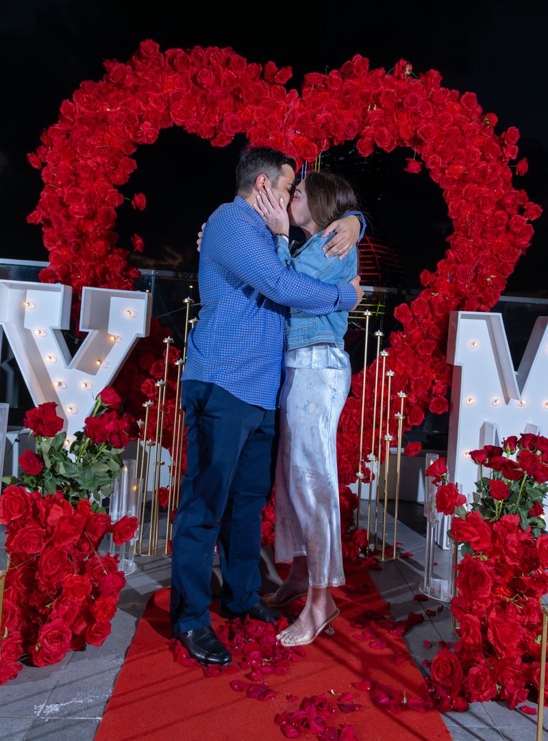 Kiss under the rose heart arch